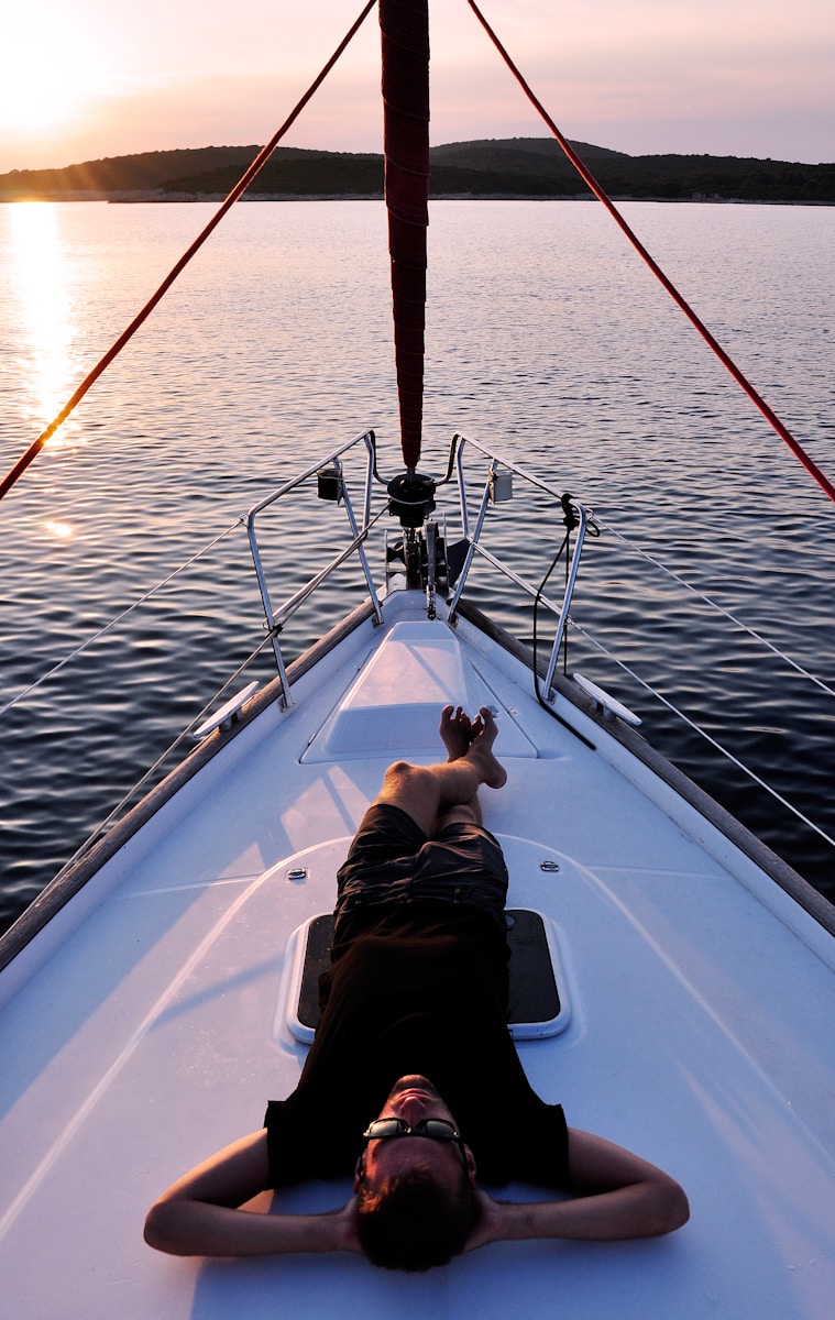 man lying on white boat with boat insurance